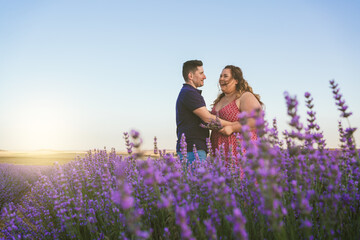 couple looking at each other and laughing in a lavender field.