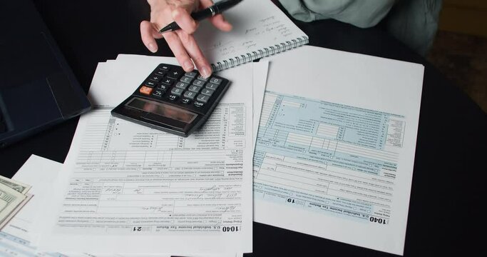 Woman calculate and filling US tax form 1040 in tax time. Individual Income Tax Return Form 1040