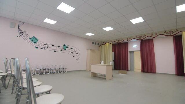 Chairs lines and table in room prepared for children performance in kindergarten. Musical holiday for kids and parents