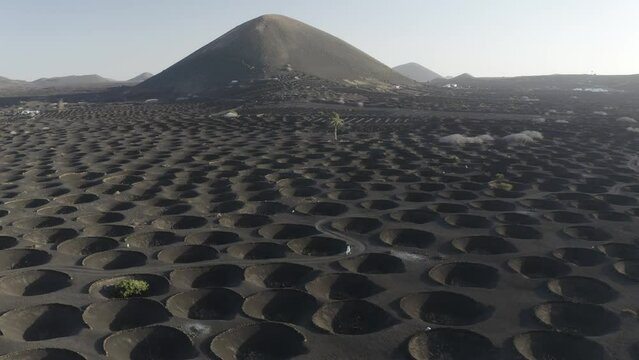 Aerial view of a woman walking among volcano holes formation at Timanfaya national park, Lanzarote Island, Canary Islands, Spain.