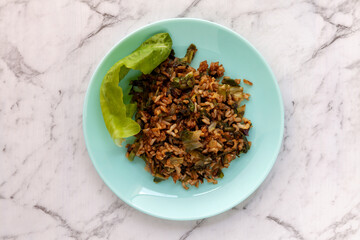 Rice fried with lettuce leaves. Top view meal plate on marble table.