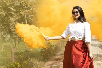 Beautiful young girl woman in spring break surround Multicolored smoke bombs cloud of dry color...
