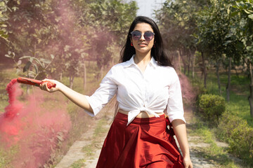 Beautiful young girl woman with smoke bombs color cloud of dry color Holi powder colour gulal abeer...