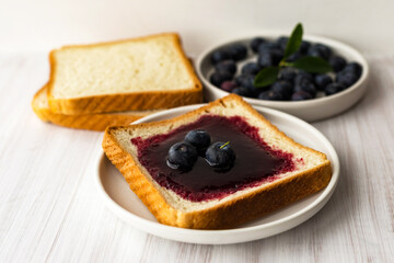 Blueberry jam bread toast and fresh berries on plate. Healthy breakfast concept