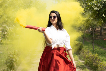Beautiful young girl woman celebrate Festival of color holi in spring break in the park celebrate...