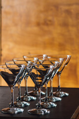 Obraz na płótnie Canvas Eight empty martini glasses with wood wall background bar