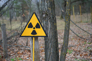 Nuclear radioactive danger sign in forest in Chernobyl exclusion zone around Chornobyl Nuclear Power Station © Milan