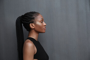 Side-view of stylish African American young woman with black braided hair.