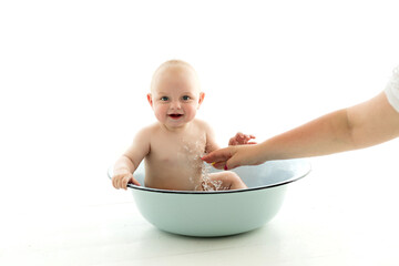 The baby is taking a bath in a blue bathtub