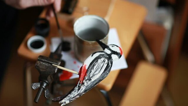 artist paints of the red-headed woodpecker on the desktop close-up