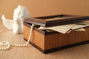 dear to heart memorabilia in an old wooden box, pearl beads, stack of retro photos, vintage...