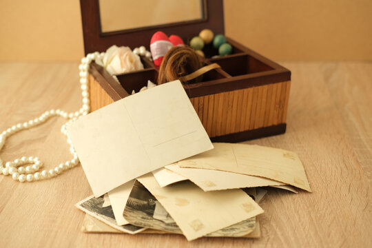 dear to heart memorabilia in an old wooden box, lock of hair, stack of retro photos, vintage photographs of 40s - 50s, concept family tree, genealogy, memories, home archive, keep as a keepsake