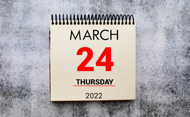 march 24. 24th day of month, calendar date. Stand for desktop calendar on beige wooden background.