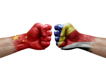 Two hands punch to each others on white background. Country flags painted fists, conflict crisis concept between china and seychelles