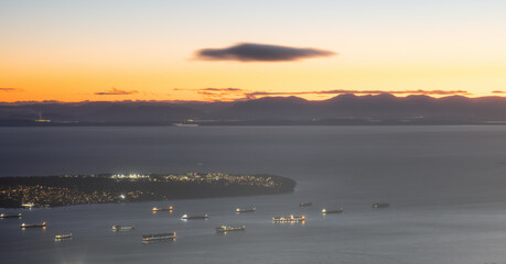 Burrard Inlet, Tanker Ships, UBC and Strait of Georgia with Island in background. Winter Sunset Twilight. View from Grouse Mountain, North Vancouver, British Columbia, Canada.