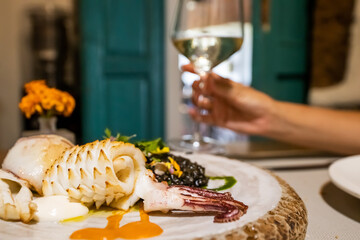 Correctly presented plate of food and a glass of wine