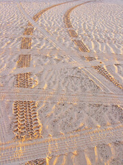 Tracks at Sunset - Vehicle tracks in the sand defined by the setting sun