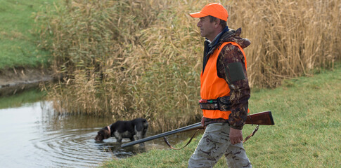 Hunter man in camouflage with a gun during the hunt in search of wild birds or game. Autumn hunting...