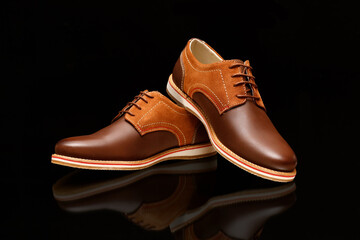 Male brown leather shoes on black background, isolated product.