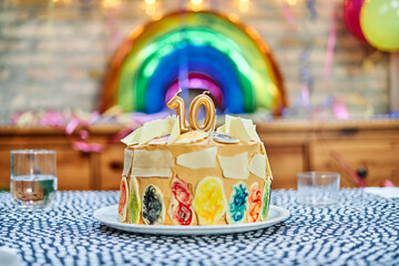 Birthday cake with the number 10 and a rainbow balloon in the background