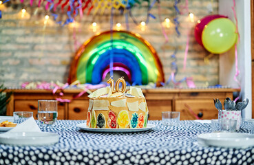 Birthday cake with the number 10 and a rainbow balloon in the background