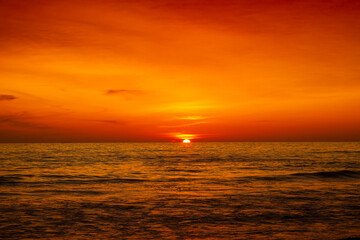 Beautiful sunset over ocean with orange and red sky