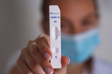 Woman showing express covid test with positive coronavirus result