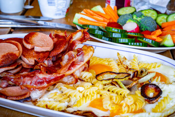 Fry eggs make fried eggs noodles sausages in the pan.