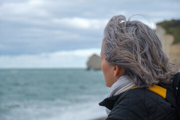 Profile view of older woman on cold beach