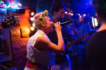 Rock band playing on the concert stage in the small night club