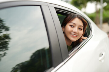 Young female passenger leaned out the window smiling