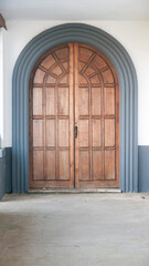 Puerta de madera con arco en claustro de iglesia rural