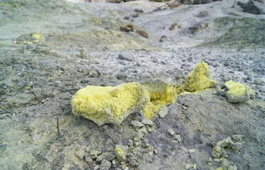 chunks of crystalline sulfur in a volcanic landscape on the slope of Mendeleev volcano, Kuril Islands