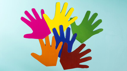 Banner abstract background open palms of colored paper close-up on a blue background.