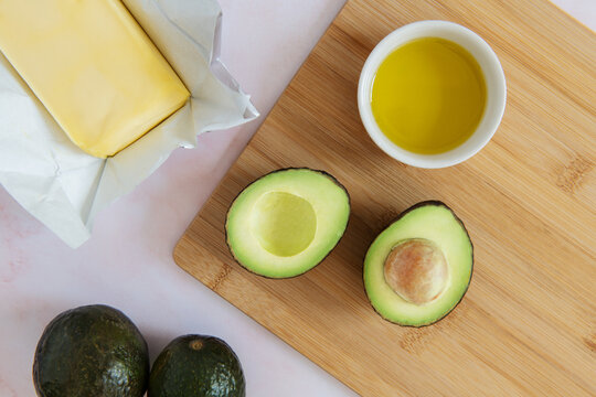 Still life of healthy fats including avocado, butter and olive oil