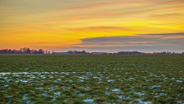 Frozen Fields Against Fiery Sky During Sunset In Winter. Timelapse