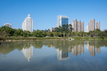 Obraz na płótnie Canvas The river reflects the modern city buildings under the blue sky