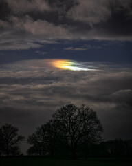 Nuage iridescent reflétant ses couleurs arc-en-ciel dans un ciel semblable à la nuit 