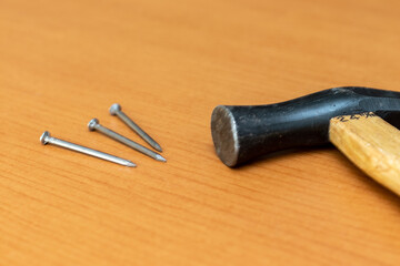 ハンマーの黒いヘッドと金属製の釘
