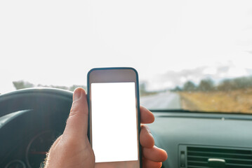 Man using blank white screen mobile smartphone inside a car in spring day landscape. copy space for your advertisement,mockup.
