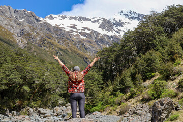 woman lifting arms in the mountains