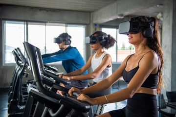 Healthy athletic man and woman wearing VR glasses workout exercise on cycling machine in virtual reality cyberspace at fitness gym. Metaverse digital entertainment technology and sport concept