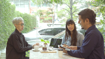 Insurance sales talking to an old Asian customer in cafe, coffee shop or restaurant, making a discussion together. People lifestyle.