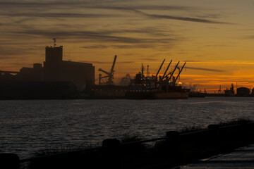 Coucher de soleil sur le port industriel de Dunkerque et silhouettes d'usines