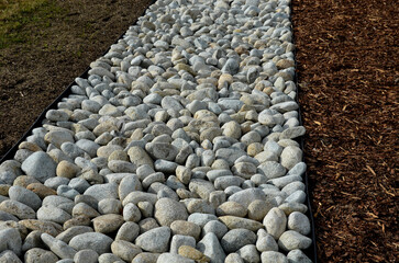 The street line is planted in a rectangular strip mulched by large white pebbles. clearer and more...