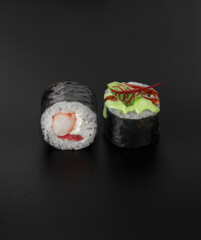 maki sushi with shrimp and wasabi sauce on black background closeup