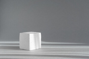 Geometric white square podium pedestal. Abstract 3d concept illuminated by rays of morning sun. Futuristic minimalistic background, close-up