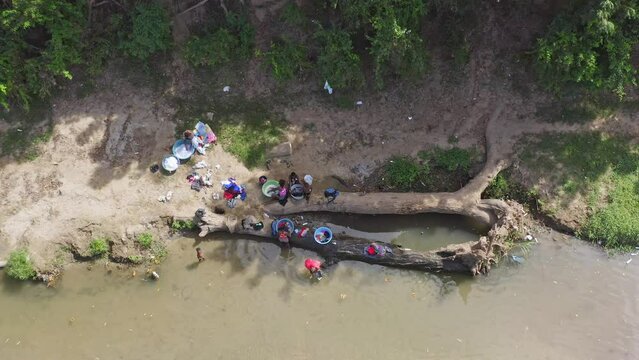Haitian women washing clothes in waters of Massacre River. Border between Haiti and Dominican Republic. Aerial top-down directly above