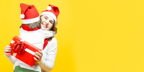 female smiling santa claus woman with little child kid embracing hugging and having fun with grace and smiling over yellow background