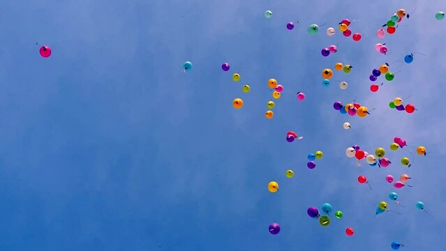 Colorful balloons flying in the blue sky. VERTICAL format